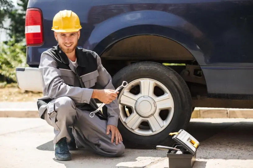 man changing tire road side